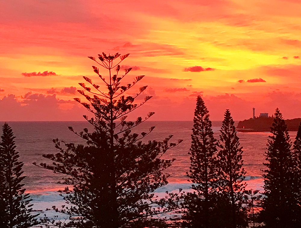 Sunshine Coast at sunset. With bright orange, pink and yellow sky. 
