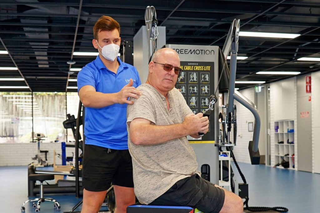 Exercise Physiologist Ernest Starowicz with a client using fitness equipment
